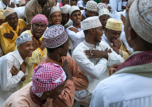 Sunni muslim men dancing during the maulidi festivities in the street, Lamu county, Lamu town, Kenya