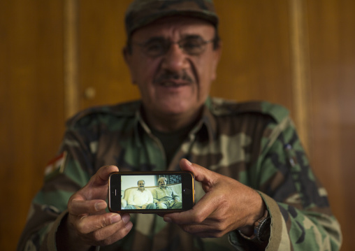 Kurdish General Peshmerga On The Frontline Showing A Picture Of Himself With President Massoud Barzani, Duhok, Kurdistan, Iraq