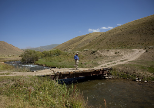 Western Man On The Bridge On Kyzart River, Kyrgyzstan