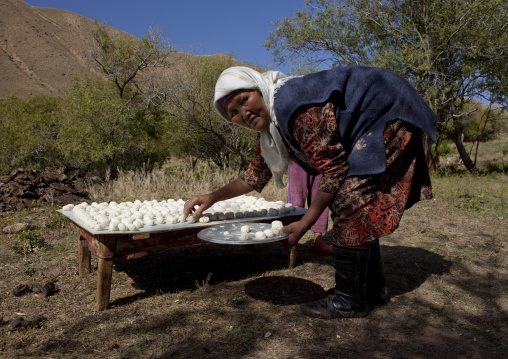 Veiled Woman Putting The Cheese She Made On A Plate, Kyzart River, Kyrgyzstan