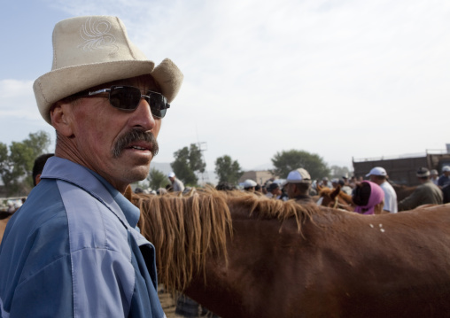 Man Wearing A Kalpak Hat And Sunglasses At The Animal Market Of Kochkor, Kyrgyzstan