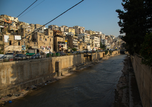 Polluted river crossing residential apartments and housing, North Governorate, Tripoli, Lebanon