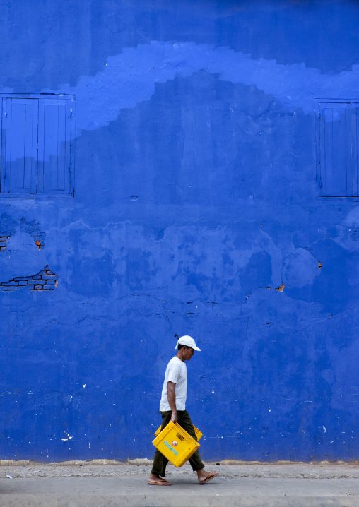 Man in front of a blue wall, Pakse, Laos