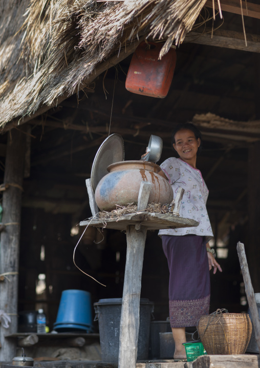 Bru minority woman puting water in a jar, Phonsaad, Laos