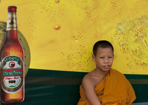 Monk in front of a beer advertising at a bus stop, Pakse, Laos