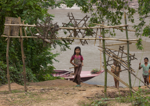 Khmu minority girl passing under the traditional gate, Xieng khouang, Laos