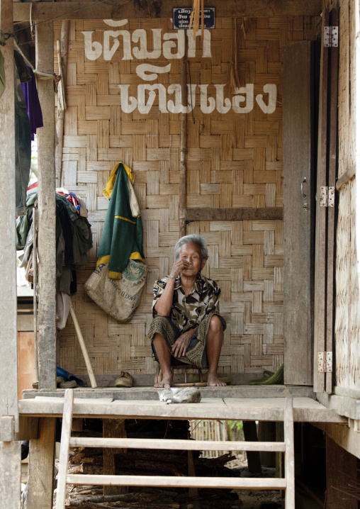 Khmu minority man sitting in front of his house, Xieng khouang, Laos