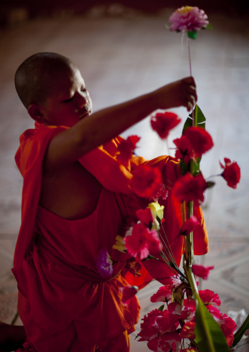 Novice buddhist monk arranging flowers, Nam deng, Laos