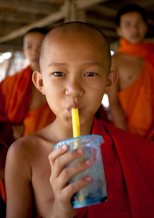 Novice buddhist monk drinking, Muang sing, Laos