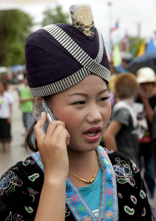 Girl with a mobile phone in traditional clothing during pii mai lao new year celebration, Luang prabang, Laos