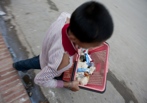 Kid bringing food for monks breakfast at early morning in luang prabang, Laos