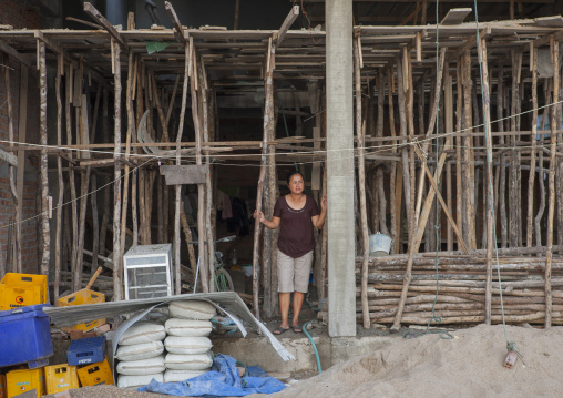 Women in front of her house in construction, Thakhek, Laos
