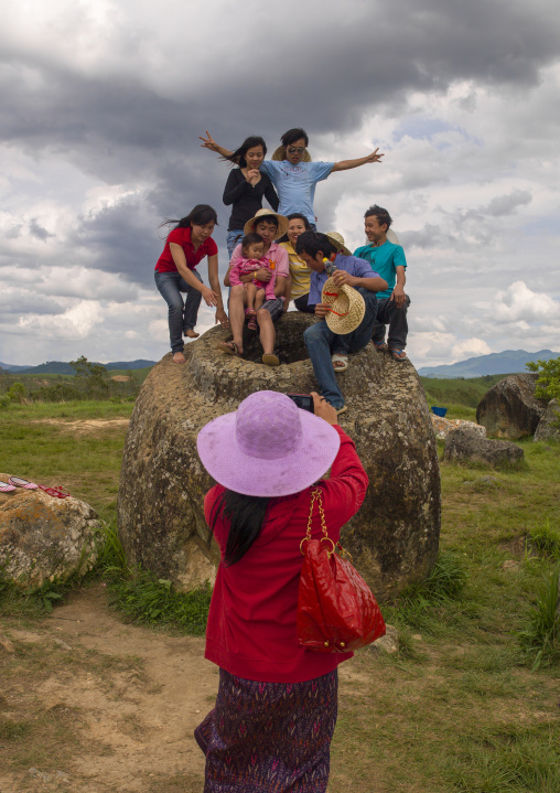 Tourists pausing on a jar, Plain of jars, Phonsavan, Laos