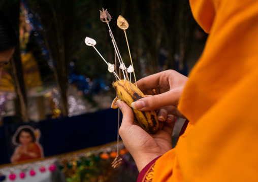 Hindu Devotee In Thaipusam Religious Festival In Batu Caves Holding Banana To Lubricate Skewers, Southeast Asia, Kuala Lumpur, Malaysia