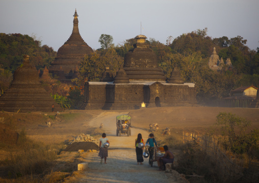 Women Carrying Water In Front Of A Buddhist Temple, Mrauk U, Myanmar