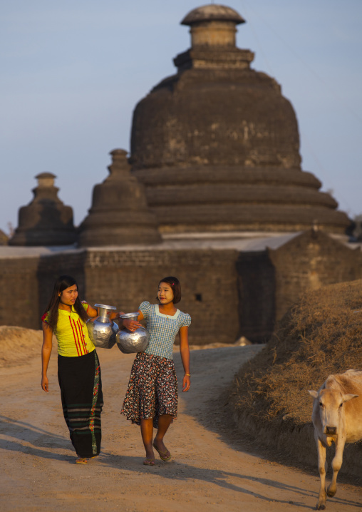 Women Carrying Water In Front Of A Buddhist Temple, Mrauk U, Myanmar