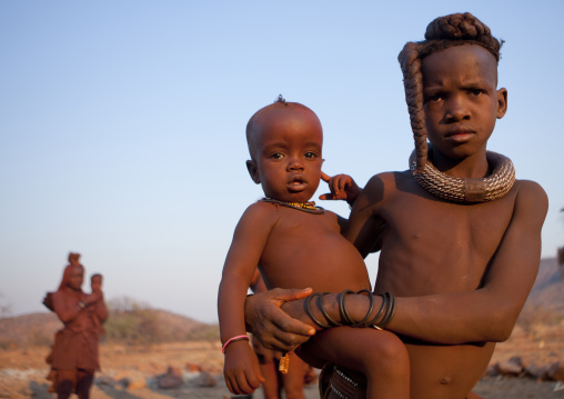 Himba Girl Taking Care Of Her Little Brother Sister, Okapale Area, Namibia