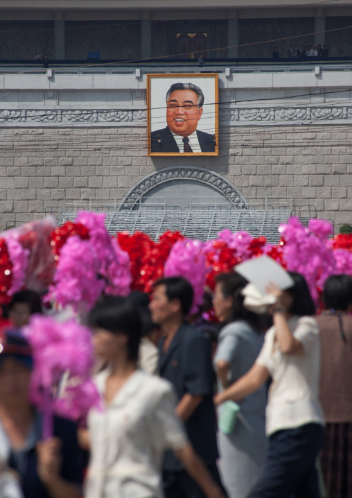 North Korean people going to the celebration of the 60th anniversary of the regim with plastic bunches of red flowers, Pyongan Province, Pyongyang, North Korea