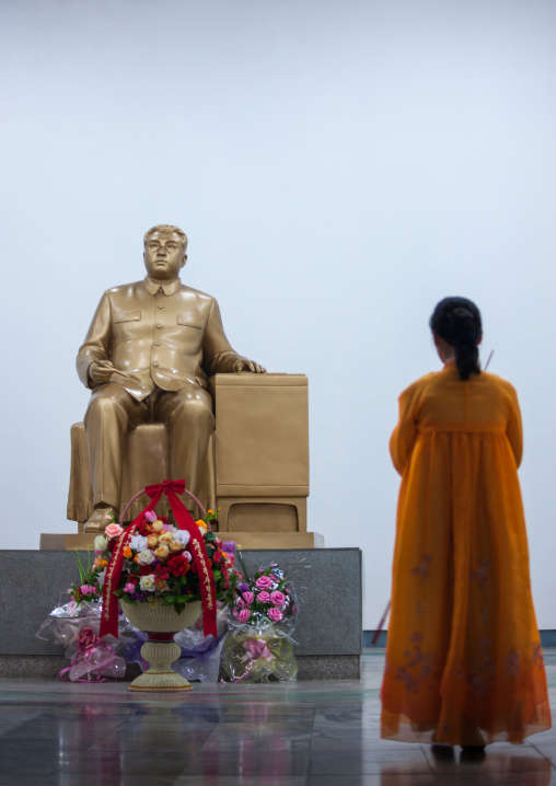 North Korean woman standing in front of a Kim il Sung golden statue in central history museum, Pyongan Province, Pyongyang, North Korea