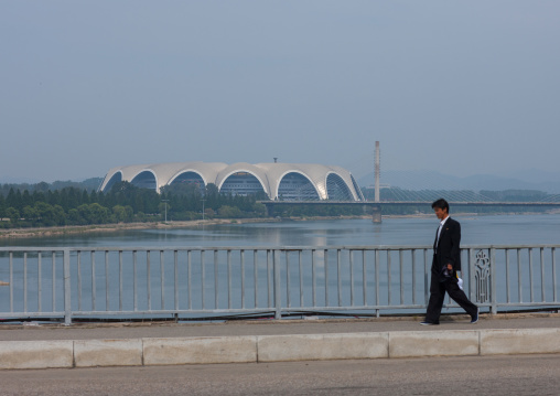 North Korean man along Taedong river with the may day stadium in the back, Pyongan Province, Pyongyang, North Korea