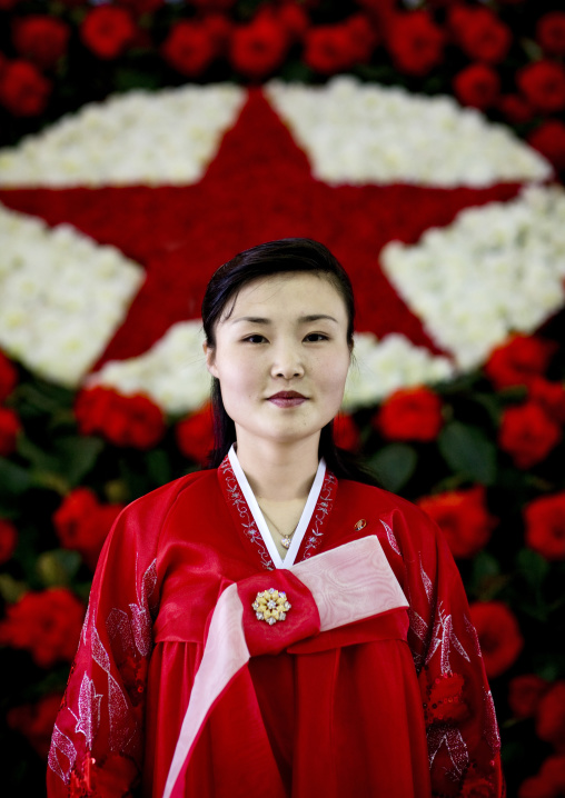 North Korean woman posing in front of a red star made of flowers at the international Kimilsungia and Kimjongilia festival, Pyongan Province, Pyongyang, North Korea
