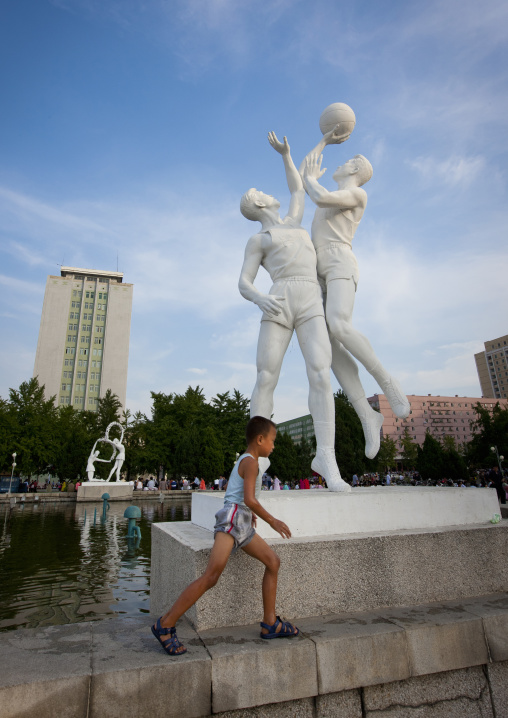 North Korean child in front of a basket ball players statue, Pyongan Province, Pyongyang, North Korea