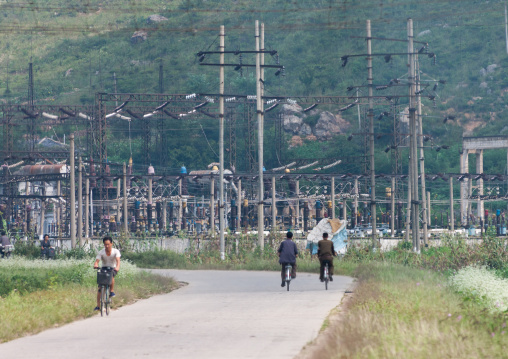 North Korean men riding in font of a power station, North Hwanghae Province, Sariwon, North Korea