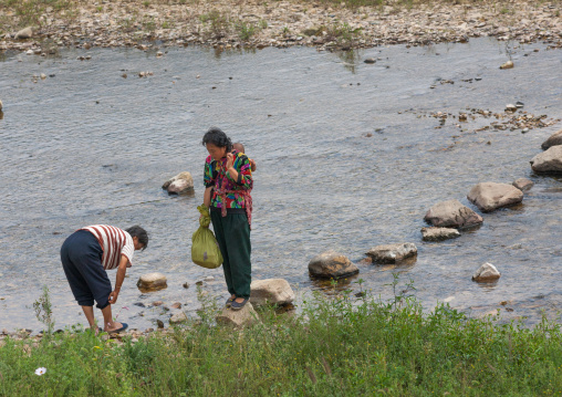North Korean women walking on stones to cross a river, North Hwanghae Province, Sariwon, North Korea