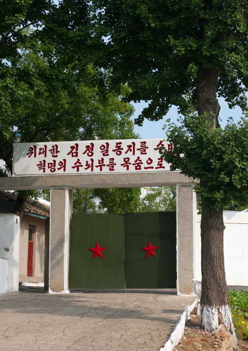 Entrance gate with red stars and a propaganda slogan above, Kangwon Province, Chonsam Cooperative Farm, North Korea