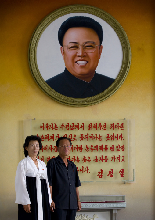North Korean people posing in front of a Kim Jong il giant picture, Kangwon Province, Chonsam Cooperative Farm, North Korea