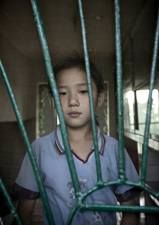 Portrait of a North Korean girl behind the bars of a window, Kangwon Province, Chonsam Cooperative Farm, North Korea