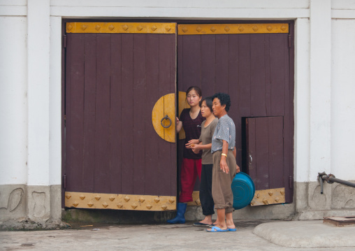 North Korean women in front of a traditional wooden door, North Hwanghae Province, Sariwon, North Korea