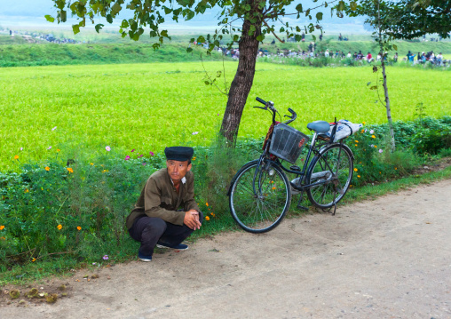 North Korean man with a bicycle resting on the roadside, North Hwanghae Province, Kaesong, North Korea