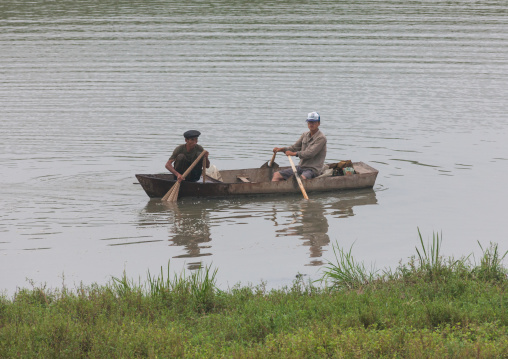 North Korean men fishing on a small boat on a lake, Pyongan Province, Pyongyang, North Korea