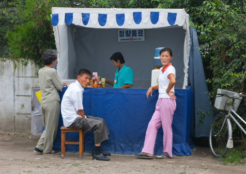 North Korean people buying drinks in a small shop in the street, Pyongan Province, Pyongyang, North Korea