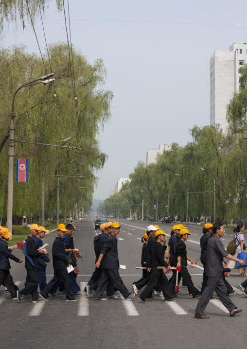 North Korean teenagers with yellow caps crossing a street, Pyongan Province, Pyongyang, North Korea