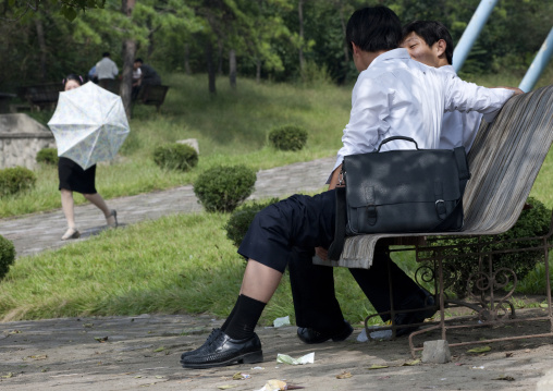 North Korean men resting on a bench in a park, Pyongan Province, Pyongyang, North Korea