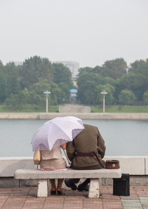 A North Korean soldier with his wife sitting on a bench, Pyongan Province, Pyongyang, North Korea
