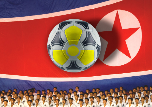 North Korean taekwondo team in front of a giant flag with a photoshoped radioactive football ball during the Arirang mass games in may day stadium, Pyongan Province, Pyongyang, North Korea