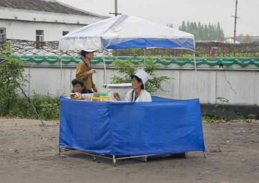 North Korean street vendor woman selling food and drinks, South Hamgyong Province, Hamhung, North Korea