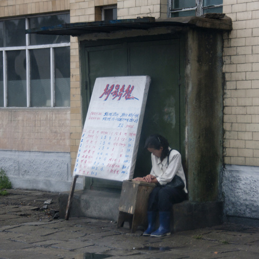 North Korean woman in the street with lottery board, South Hamgyong Province, Hamhung, North Korea