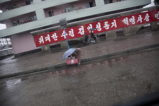 North Korean woman bending over in the street, South Hamgyong Province, Hamhung, North Korea