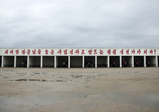 Storage for farm vehicles with a slogan on the top, South Hamgyong Province, Hamhung, North Korea