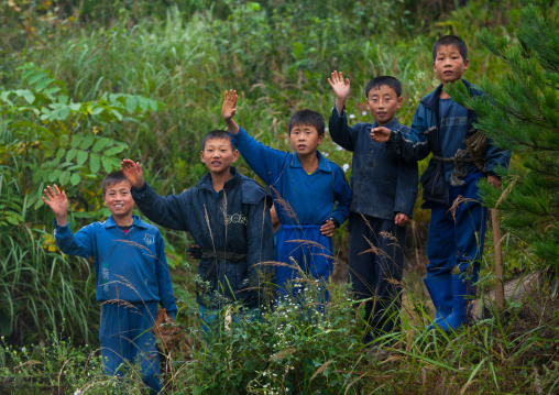 North Korean group of children waving hands in the countryside, North Hamgyong Province, Jung Pyong Ri, North Korea