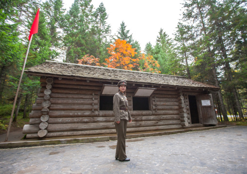 Tourist guide in front of a log cabin in the secret camp no.1 hq of the Korean people's army, Ryanggang Province, Samjiyon, North Korea