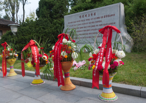 Baskets of flowers in front of a stele dedicated to the Dear Leaders, Pyongan Province, Pyongyang, North Korea