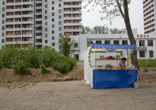 Food stall with no customers in front of apartment blocks, Pyongan Province, Pyongyang, North Korea