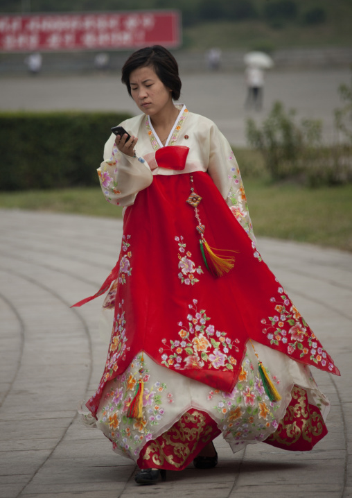 North Korean woman in choson-ot using her mobile phone in the street, Pyongan Province, Pyongyang, North Korea
