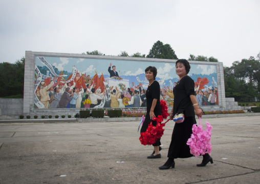 North Korean women with plastic flowers going celebrate the day of the foundation of the republic, Pyongan Province, Pyongyang, North Korea
