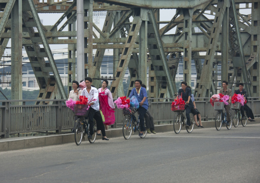 Group of North Korean women cycling across a bridge, Pyongan Province, Pyongyang, North Korea